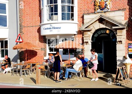 Les touristes se détendant à l'extérieur du café Custom House le long du quai dans le port, Weymouth, Dorset, Royaume-Uni, Europe. Banque D'Images