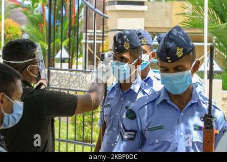 Un soldat de l'armée sri-lankaise effectue des contrôles de température sur des soldats de l'armée de l'air portant des masques protecteurs lors d'une répétition avant la « Journée nationale des héros de guerre » (qui aura lieu le 19 mai) Célébrez le 11th anniversaire de la victoire de guerre du Sri Lanka sur l'organisation terroriste LTTE au Monument national des héros de guerre, Colombo, Sri Lanka, on 18 mai 2020. . (Photo de Thharaka Basnayaka/NurPhoto) Banque D'Images