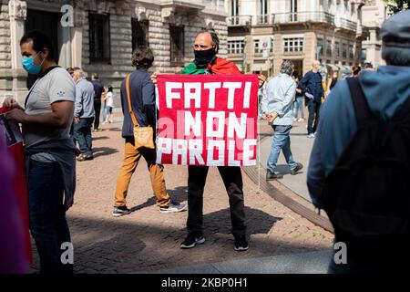 Les vendeurs de rue protestent devant le Palazzo Marino avec des panneaux et des bannières contre les mesures de la phase 2 du confinement du coronavirus qui ne leur permettent pas de reprendre leurs activités le 18th mai 2020 à Milan, Italie. (Photo par Alessandro Bremec/NurPhoto) Banque D'Images