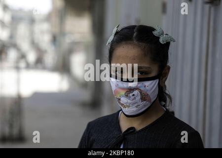 Une fillette palestinienne portant un masque facial protecteur se promène dans une rue de la ville de Gaza, à 19 mai 2020, pendant la crise pandémique du coronavirus. (Photo de Majdi Fathi/NurPhoto) Banque D'Images