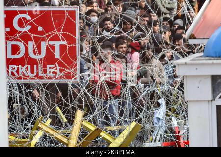 On voit un bébé parmi les migrants protestataires qui veulent entrer en Grèce de manière illégitime. Les groupes de migrants au poste-frontière de Pazarkule et Kastanies, composés principalement de personnes venant d'Afghanistan, sont bloqués entre les frontières grecques et turques, au poste frontière de Kastanies en Grèce et à celui de Pazarkule près d'Edirne en Turquie, dans la zone neutre. Les migrants et les réfugiés tentent d'entrer en Europe via la Grèce. Les demandeurs d'asile protestent et lancent des pierres et du gaz lacrymogène vers les forces de sécurité, la police et l'armée grecques qui réagissent avec des gaz à effet de lance et des grenades à éclats. . La Turquie a annoncé qu'elle ouvrirait les portes de la frontière pour un pério Banque D'Images
