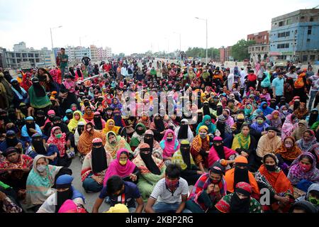 Les ouvriers bangladais du vêtement bloquent une route alors qu'ils se rassemblent pour protester contre leurs salaires impayés lors de leur confinement dans tout le pays afin de freiner la propagation du coronavirus à Dhaka, au Bangladesh, au 20 mai 2020. (Photo de Sony Ramany/NurPhoto) Banque D'Images