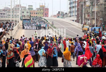 Les ouvriers bangladais du vêtement bloquent une route alors qu'ils se rassemblent pour protester contre leurs salaires impayés lors de leur confinement dans tout le pays afin de freiner la propagation du coronavirus à Dhaka, au Bangladesh, au 20 mai 2020. (Photo de Sony Ramany/NurPhoto) Banque D'Images