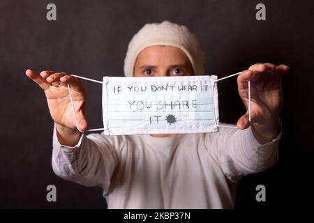 À titre d'illustration, une femme porte un masque protecteur avec une note « si vous ne le portez pas, vous le partagez » sur 20 mai 2020 à Cracovie, en Pologne. (Photo d'illustration par Dominika Zarzycka/NurPhoto) Banque D'Images