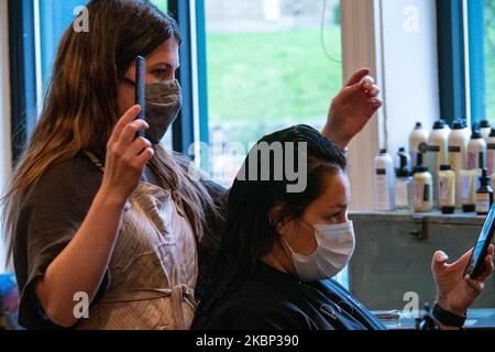 Un cosmétologue coiffe les cheveux d'un client au salon de salon de coiffure alors que les salons de beauté, les salons de coiffure et les spas commencent à rouvrir à la suite de la pandémie du coronavirus COVID-19, mercredi, 20 mai 2020, à Cincinnati, Ohio, États-Unis. (Photo de Jason Whitman/NurPhoto) Banque D'Images