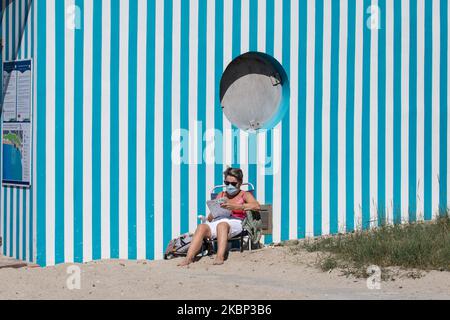 Une femme masquée lit près de la plage à Granville, en France, sur 20 mai 2020 , après avoir assouplit les mesures de confinement prises pour freiner la propagation du COVID-19 (le nouveau coronavirus). Trois villes du nord-ouest de la France fermera leurs plages quelques jours seulement après leur réouverture après deux mois de confinement du coronavirus, déclarant que trop de visiteurs étaient en train de se déjouer des règles de distance sociale (photo par Ibrahim Ezzat/NurPhoto) Banque D'Images