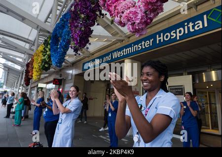 Les médecins et les infirmières se sont accroché les mains à l'extérieur de l'hôpital de Chelsea et Westminster lors des applaudissements hebdomadaires « Clap for our Carers » pour le NHS et les principaux travailleurs en première ligne de la pandémie du coronavirus (Covid-19), alors que le confinement national du Royaume-Uni se poursuit pour la neuvième semaine le 21 mai 2020 à Londres, Angleterre. (Photo de Wiktor Szymanowicz/NurPhoto) Banque D'Images