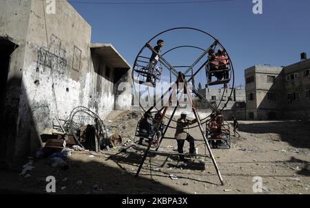 Les enfants palestiniens sont à bord d'une grande roue pendant les vacances d'Eid al-Fitr, en raison de préoccupations quant à la propagation de la maladie à coronavirus (COVID-19), dans la ville de Gaza, à 26 mai 2020. (Photo de Majdi Fathi/NurPhoto) Banque D'Images