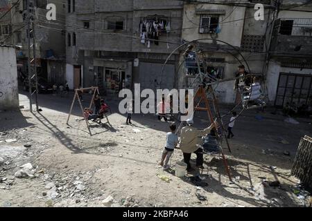 Les enfants palestiniens sont à bord d'une grande roue pendant les vacances d'Eid al-Fitr, en raison de préoccupations quant à la propagation de la maladie à coronavirus (COVID-19), dans la ville de Gaza, à 26 mai 2020. (Photo de Majdi Fathi/NurPhoto) Banque D'Images