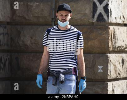 Un gars marche à travers la ville avec un masque et des gants pendant la normalisation de la vie après le verrouillage du coronavirus (COVID-19) à Belgrade, Serbie sur 26 mai 2020. Suite à la baisse du nombre de patients atteints du coronavirus, le gouvernement de cette semaine a aboli l'état d'urgence. (Photo par Nikola Krstic/NurPhoto) Banque D'Images