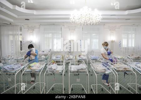 Les baby-sitters transportent les bébés dans leur berceau après leur repas dans une chambre à l'intérieur de l'hôtel de Venise, propriété de la clinique BioTexCom à Kiev, Ukraine, 19 mai 2020. 56 bébés nés de mères porteuses dans la clinique ukrainienne BioTexCom pour des parents de Chine, Espagne, Allemagne, France, Italie, La Bulgarie et la Roumanie attendent leurs parents biologiques qui ne peuvent pas atteindre l'Ukraine en raison de la fermeture des frontières pendant la pandémie du coronavirus COVID-19. (Photo par Sergii Kharchenko/NurPhoto) Banque D'Images