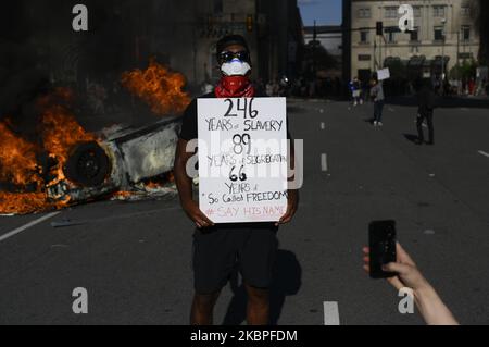 Un homme afro-américain pose avec un chantant devant un croiseur de police en feu et renversé alors que les manifestants se battent contre la police près de l'hôtel de ville, à Philadelphie, PA sur 30 mai 2020. Des milliers de villes autour de la nation descendent dans la rue pour protester contre la brutalité policière après le meurtre de George Floyd. (Photo de Bastiaan Slabbers/NurPhoto) Banque D'Images