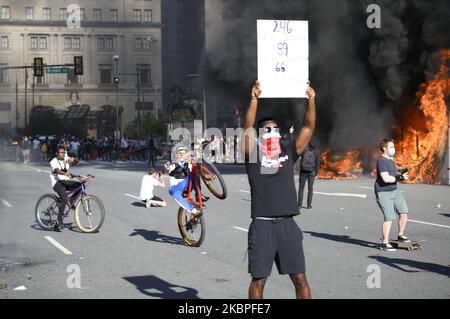 Un homme afro-américain se pose avec une chante devant des véhicules de police en feu alors que les manifestants se battent contre la police près de l'hôtel de ville, à Philadelphie, en Pennsylvanie, sur 30 mai 2020. Des milliers de villes autour de la nation descendent dans la rue pour protester contre la brutalité policière après le meurtre de George Floyd. (Photo de Bastiaan Slabbers/NurPhoto) Banque D'Images