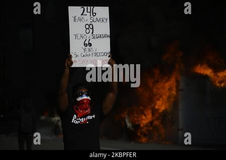 Un homme afro-américain se pose avec une chante devant des véhicules de police en feu alors que les manifestants se battent contre la police près de l'hôtel de ville, à Philadelphie, en Pennsylvanie, sur 30 mai 2020. Des milliers de villes autour de la nation descendent dans la rue pour protester contre la brutalité policière après le meurtre de George Floyd. (Photo de Bastiaan Slabbers/NurPhoto) Banque D'Images