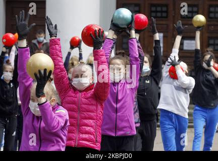 Les gymnastes de l'école Deriugina portant des masques protecteurs dans le cadre de l'épidémie du coronavirus Covid-19 prennent part à une séance de formation dans le centre de Kiev, en Ukraine, le 01 juin 2020. Les jeunes gymnastes ont suivi une formation dans une rue pour soutenir l'action 'Save Deriugina School', qui a été organisée à l'appui de l'Irina Deryugina école de gymnastique pour enfants et jeunes. (Photo par STR/NurPhoto) Banque D'Images