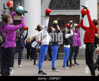 Les gymnastes de l'école Deriugina portant des masques protecteurs dans le cadre de l'épidémie du coronavirus Covid-19 prennent part à une séance de formation dans le centre de Kiev, en Ukraine, le 01 juin 2020. Les jeunes gymnastes ont suivi une formation dans une rue pour soutenir l'action 'Save Deriugina School', qui a été organisée à l'appui de l'Irina Deryugina école de gymnastique pour enfants et jeunes. (Photo par STR/NurPhoto) Banque D'Images
