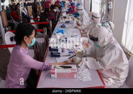 Le personnel médical utilisant un équipement de protection individuelle (EPI) complet prélève des échantillons de sang auprès des résidents pendant le test rapide Covid-19 à Surabaya, Java-est, sur 3 juin 2020. Le gouvernement indonésien procède intensivement à des tests rapides et à des tests par écouvillonnage pour anticiper la propagation de Covid-19. On espère que de cette façon, les personnes avec Covid-19 peuvent être détectées et isolées pour un traitement médical. (Photo de Suryanto Putramudji/NurPhoto) Banque D'Images