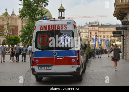 Vue sur une ambulance vue sur la place du marché principal de Cracovie. Depuis 5 avril, la moyenne mobile de 7 jours d'un nouveau cas quotidien de coronavirus en Pologne varie entre 297 et 401. Le ministère de la Santé a signalé aujourd'hui 361 nouveaux cas et 2 décès, ce qui porte le nombre total à 25 048 personnes infectées, 1 117 décès et 12 227 cas de rétablissement. Sur 04 juin 2020, à Cracovie, en Pologne. (Photo par Artur Widak/NurPhoto) Banque D'Images