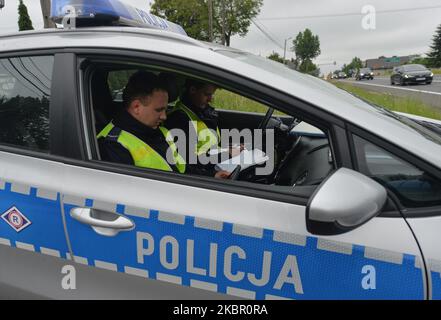 Deux policiers ont été vus lors d'un contrôle de vitesse sur la route nationale 94, près du village de Bialy Kosciol. Le service de police de Cracovie a lancé une nouvelle initiative intitulée « de Katowice à Cracovie, c'est la bonne vitesse ». À partir de 8 juin, les patrouilles routières dans les régions de la petite Pologne et de la Silésie seront axées sur l'amélioration de la sécurité des usagers de la route et l'élimination des comportements qui ont un impact négatif sur la sécurité routière. Sur 8 juin 2020, à Bialy Kosciol, comté de Cracovie, Pologne. (Photo par Artur Widak/NurPhoto) Banque D'Images