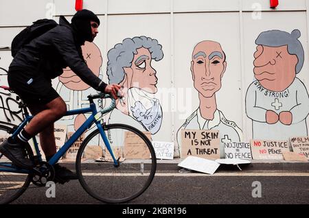 Un cycliste passe devant une fresque peinte sur une couverture en bois sur la rue du Parlement, tandis que les militants de Black Lives Matter, réunis pour la deuxième journée consécutive de protestation de masse contre le racisme, manifestent à Londres, en Angleterre, sur 7 juin 2020. Aujourd'hui a marqué la quatrième manifestation massive de Black Lives Matter à Londres en huit jours, dans le cadre d'une vague mondiale de manifestations anti-racisme suscitée par le meurtre d'un homme noir, George Floyd, sous la garde de la police, dans la ville américaine de Minneapolis, sur 25 mai. (Photo de David Cliff/NurPhoto) Banque D'Images