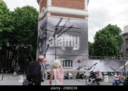 Un couple parisien regarde une fresque à Paris de l'artiste de rue JR et des étudiants de l'école de cinéma du réalisateur Ladj Ly où est vu un oeil de George Floyd et un autre oeil d'Adama Traore, à Paris, France, sur 10 juin 2020 (photo de Daniel Pier/NurPhoto) Banque D'Images