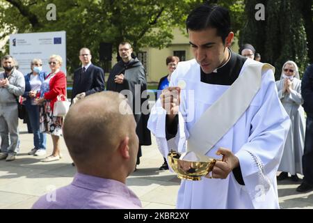 Les catholiques célèbrent Corpus Christi qui participe à la Messe et à la procession pendant la propagation du coronavirus. Cracovie, Pologne, le 11 juin 2020. La procession commence par un prêtre portant une Monstruce sous une verrière. Les fidèles le suivent, chantant des hymnes religieux, tandis que les jeunes filles vêtues de robes régionales blanches ou traditionnelles dispersent les pétales de fleurs le long du parcours. Corpus Christi est une fête mobilier catholique commémorant la Transubstitution. (Photo de Beata Zawrzel/NurPhoto) Banque D'Images