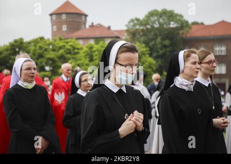 Les religieuses célèbrent Corpus Christi qui participe à la Messe et à la procession pendant la propagation du coronavirus. Cracovie, Pologne, le 11 juin 2020. La procession commence par un prêtre portant une Monstruce sous une verrière. Les fidèles le suivent, chantant des hymnes religieux, tandis que les jeunes filles vêtues de robes régionales blanches ou traditionnelles dispersent les pétales de fleurs le long du parcours. Corpus Christi est une fête mobilier catholique commémorant la Transubstitution. (Photo de Beata Zawrzel/NurPhoto) Banque D'Images