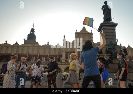 Un groupe de jeunes portant des drapeaux LGBT ont vu danser à côté du monument Adam Mickiewicz, sur la place du marché principal de Cracovie. Une douzaine de jeunes activistes ont répondu par leur présence à un événement non officiel Facebook appelé "Une discothèque Rainbow sur la place principale". Après environ 15min de l'événement, les activistes ont pris une photo de groupe au monument Mickiewicz. Quelques minutes plus tard, deux pistes avec des membres de la police locale sont arrivées et ont commencé à vérifier les pièces d'identité des activistes et ainsi mettre fin à l'événement. Le lundi 12 vendredi 2020, à Cracovie, en Pologne. (Photo par Artur Widak/NurPhoto) Banque D'Images