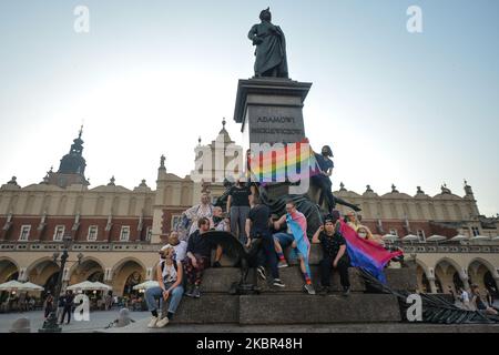 Un groupe de jeunes portant des drapeaux LGBT ont vu danser à côté du monument Adam Mickiewicz, sur la place du marché principal de Cracovie. Une douzaine de jeunes activistes ont répondu par leur présence à un événement non officiel Facebook appelé "Une discothèque Rainbow sur la place principale". Après environ 15min de l'événement, les activistes ont pris une photo de groupe au monument Mickiewicz. Quelques minutes plus tard, deux pistes avec des membres de la police locale sont arrivées et ont commencé à vérifier les pièces d'identité des activistes et ainsi mettre fin à l'événement. Le lundi 12 vendredi 2020, à Cracovie, en Pologne. (Photo par Artur Widak/NurPhoto) Banque D'Images