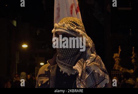 Palestinien avec foulard lors d'une manifestation massive à Athènes, en Grèce, sur 8 décembre 2017 contre la décision de Trump de reconnaître Jérusalem comme « capitale d'Israël ». Des Palestiniens de tous âges, hommes, femmes et enfants, se sont frapillés jusqu'à l'ambassade américaine, portant des banderoles, des drapeaux palestiniens, des pancartes improvisées, et ils ont dénoncé l'état sioniste meurtrier d'Israël et des États-Unis. De leur côté, on a trouvé des milliers de partisans qui ont repris des slogans comme ''la libération de la Palestine'', ''il n'y a pas de paix sans justice, les mains de la Palestine''. Les manifestants se sont joints à leurs voix avec les pates Banque D'Images