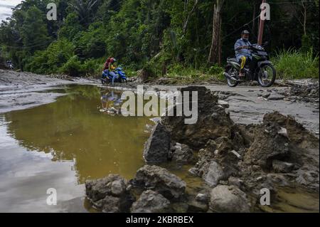 Les motocyclistes traversent la route qui a été débarrassée de boue en raison des inondations et des glissements de terrain dans le village de Tuva, la régence de Sigi, province centrale de Sulawesi, en Indonésie sur 18 juin 2020. Deux villages de la région ont été touchés par des inondations et des glissements de terrain en raison de l'intensité des pluies en début de matinée. Bien qu'elle n'ait pas causé de pertes, la catastrophe naturelle a endommagé les zones résidentielles, y compris les établissements scolaires et les lieux de culte. Presque chaque année, les deux régions sont frappées par des inondations et des glissements de terrain pendant la saison des pluies. (Photo de Basri Marzuki/NurPhoto) Banque D'Images