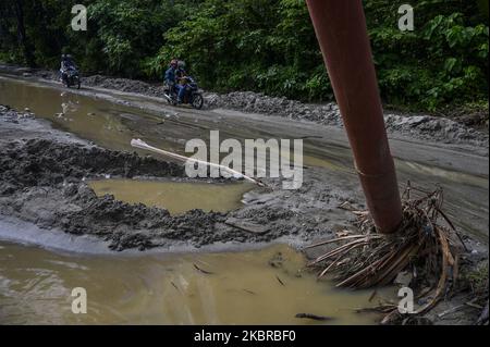 Les motocyclistes traversent la route qui a été débarrassée de boue en raison des inondations et des glissements de terrain dans le village de Tuva, la régence de Sigi, province centrale de Sulawesi, en Indonésie sur 18 juin 2020. Deux villages de la région ont été touchés par des inondations et des glissements de terrain en raison de l'intensité des pluies en début de matinée. Bien qu'elle n'ait pas causé de pertes, la catastrophe naturelle a endommagé les zones résidentielles, y compris les établissements scolaires et les lieux de culte. Presque chaque année, les deux régions sont frappées par des inondations et des glissements de terrain pendant la saison des pluies. (Photo de Basri Marzuki/NurPhoto) Banque D'Images