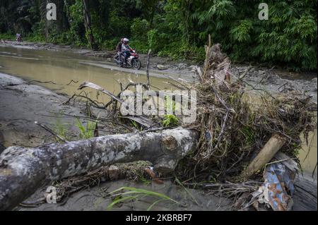 Les motocyclistes traversent la route qui a été débarrassée de boue en raison des inondations et des glissements de terrain dans le village de Tuva, la régence de Sigi, province centrale de Sulawesi, en Indonésie sur 18 juin 2020. Deux villages de la région ont été touchés par des inondations et des glissements de terrain en raison de l'intensité des pluies en début de matinée. Bien qu'elle n'ait pas causé de pertes, la catastrophe naturelle a endommagé les zones résidentielles, y compris les établissements scolaires et les lieux de culte. Presque chaque année, les deux régions sont frappées par des inondations et des glissements de terrain pendant la saison des pluies. (Photo de Basri Marzuki/NurPhoto) Banque D'Images