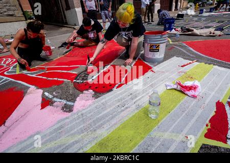 Dix-sept artistes noirs et leurs assistants peignent une peinture murale Black Lives Matter sur la rue Plumb, sur les traces de l'hôtel de ville, jeudi, 18 juin 2020, à Cincinnati, Ohio, États-Unis. (Photo de Jason Whitman/NurPhoto) Banque D'Images