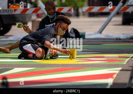 Dix-sept artistes noirs et leurs assistants peignent une peinture murale Black Lives Matter sur la rue Plumb, sur les traces de l'hôtel de ville, jeudi, 18 juin 2020, à Cincinnati, Ohio, États-Unis. (Photo de Jason Whitman/NurPhoto) Banque D'Images