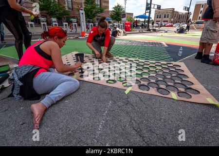 Dix-sept artistes noirs et leurs assistants peignent une peinture murale Black Lives Matter sur la rue Plumb, sur les traces de l'hôtel de ville, jeudi, 18 juin 2020, à Cincinnati, Ohio, États-Unis. (Photo de Jason Whitman/NurPhoto) Banque D'Images