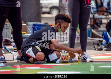 Dix-sept artistes noirs et leurs assistants peignent une peinture murale Black Lives Matter sur la rue Plumb, sur les traces de l'hôtel de ville, jeudi, 18 juin 2020, à Cincinnati, Ohio, États-Unis. (Photo de Jason Whitman/NurPhoto) Banque D'Images