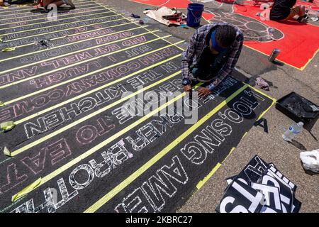 Dix-sept artistes noirs et leurs assistants peignent une peinture murale Black Lives Matter sur la rue Plumb, sur les traces de l'hôtel de ville, jeudi, 18 juin 2020, à Cincinnati, Ohio, États-Unis. (Photo de Jason Whitman/NurPhoto) Banque D'Images