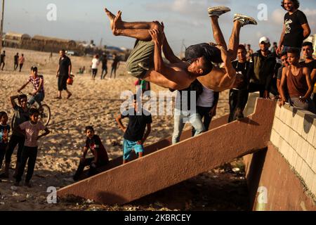 Des jeunes palestiniens démontrent ses capacités de parkour sur une plage, en raison de préoccupations quant à la propagation de la coronavirus (COVID-19), dans la ville de Gaza, au 19 juin 2020. (Photo de Majdi Fathi/NurPhoto) Banque D'Images