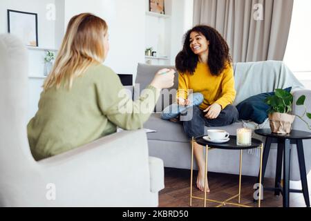 Une jeune femme afro-américaine a une séance avec son psychologue. Une patiente de race mixte est en contact avec un entraîneur mental dans sa salle de conseil privée Banque D'Images