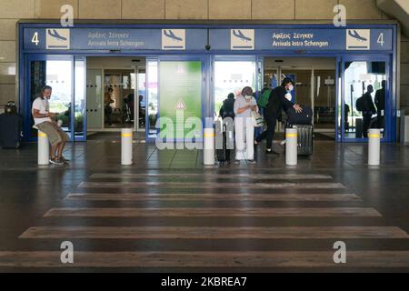 Passagers vus avec les masques obligatoires à l'aéroport international d'Athènes ATH LGAV à Athènes, Grèce sur 18 juin 2020, après la quarantaine de confinement du coronavirus et les restrictions de voyage. Les passagers portant des masques et des gants, utilisant des désinfectants pour les mains comme mesure préventive contre la propagation de la pandémie COVID-19. La Grèce et l'Europe ont fermé les frontières des personnes en dehors de l'Europe et de la zone Schengen pendant longtemps, mais la Grèce a commencé à lever l'interdiction de circulation depuis 15 juin 2020 pour les pays de la zone Schengen et l'1 juillet 2020 aura davantage d'assouplissement. Les passagers arrivant sont soumis à des Banque D'Images