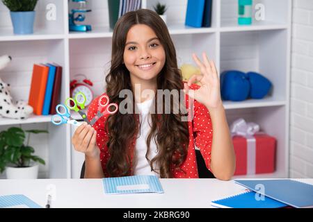 Fille d'école de l'adolescence avec des ciseaux. Idées de bricolage pour les enfants. Amour et art de l'enfant concept de passe-temps. Bonne écolière, émotions positives et souriantes. Banque D'Images