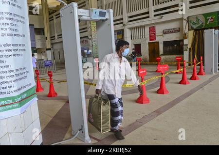 Le passager porte un masque de visage traversant une porte électronique pour mesurer la température corporelle à l'intérieur de la gare de Kamalapur pendant l'épidémie de coronavirus à Dhaka, au Bangladesh, sur 24 juin 2020 (photo de Mamunur Rashid/NurPhoto) Banque D'Images