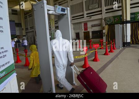 Le passager porte un masque de visage traversant une porte électronique pour mesurer la température corporelle à l'intérieur de la gare de Kamalapur pendant l'épidémie de coronavirus à Dhaka, au Bangladesh, sur 24 juin 2020 (photo de Mamunur Rashid/NurPhoto) Banque D'Images