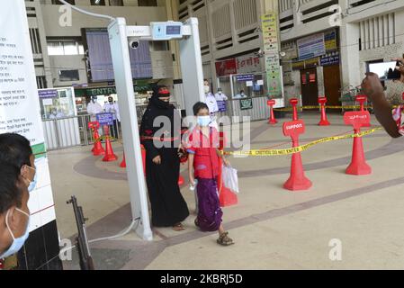 Le passager porte un masque de visage traversant une porte électronique pour mesurer la température corporelle à l'intérieur de la gare de Kamalapur pendant l'épidémie de coronavirus à Dhaka, au Bangladesh, sur 24 juin 2020 (photo de Mamunur Rashid/NurPhoto) Banque D'Images