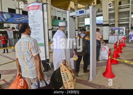 Le passager porte un masque de visage traversant une porte électronique pour mesurer la température corporelle à l'intérieur de la gare de Kamalapur pendant l'épidémie de coronavirus à Dhaka, au Bangladesh, sur 24 juin 2020 (photo de Mamunur Rashid/NurPhoto) Banque D'Images