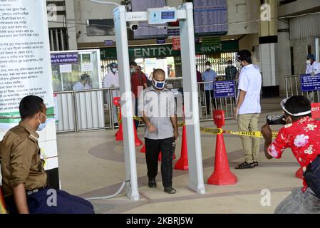 Le passager porte un masque de visage traversant une porte électronique pour mesurer la température corporelle à l'intérieur de la gare de Kamalapur pendant l'épidémie de coronavirus à Dhaka, au Bangladesh, sur 24 juin 2020 (photo de Mamunur Rashid/NurPhoto) Banque D'Images