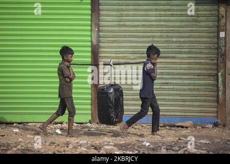 Les enfants bangladais transportent une plaque d'acier lourde dans un chantier naval situé sur la rive du fleuve Buriganga, à Dhaka, au 24 juin 2020. Vingt-huit chantiers navals occupant 30,96 acres de l'estran du Buriganga sont en service depuis 50 ans sans aucune autorisation ou directives, polluant le fleuve et empiétant sur les berges, réduisant ainsi sa navigabilité. (Photo d'Ahmed Salahuddin/NurPhoto) Banque D'Images