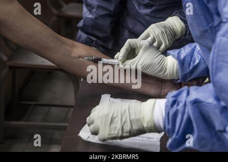 Les fonctionnaires du ministère de la Santé effectuent des tests rapides sur les personnes suspectées de covid-19. (Photo par Luis Morillo/NurPhoto) Banque D'Images