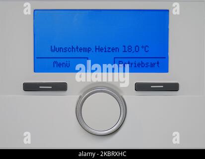 Augmentation des coûts de chauffage : les gens règlent la température à la maison en utilisant les réglages de la chaudière à condensation de gaz pour économiser l'énergie Banque D'Images